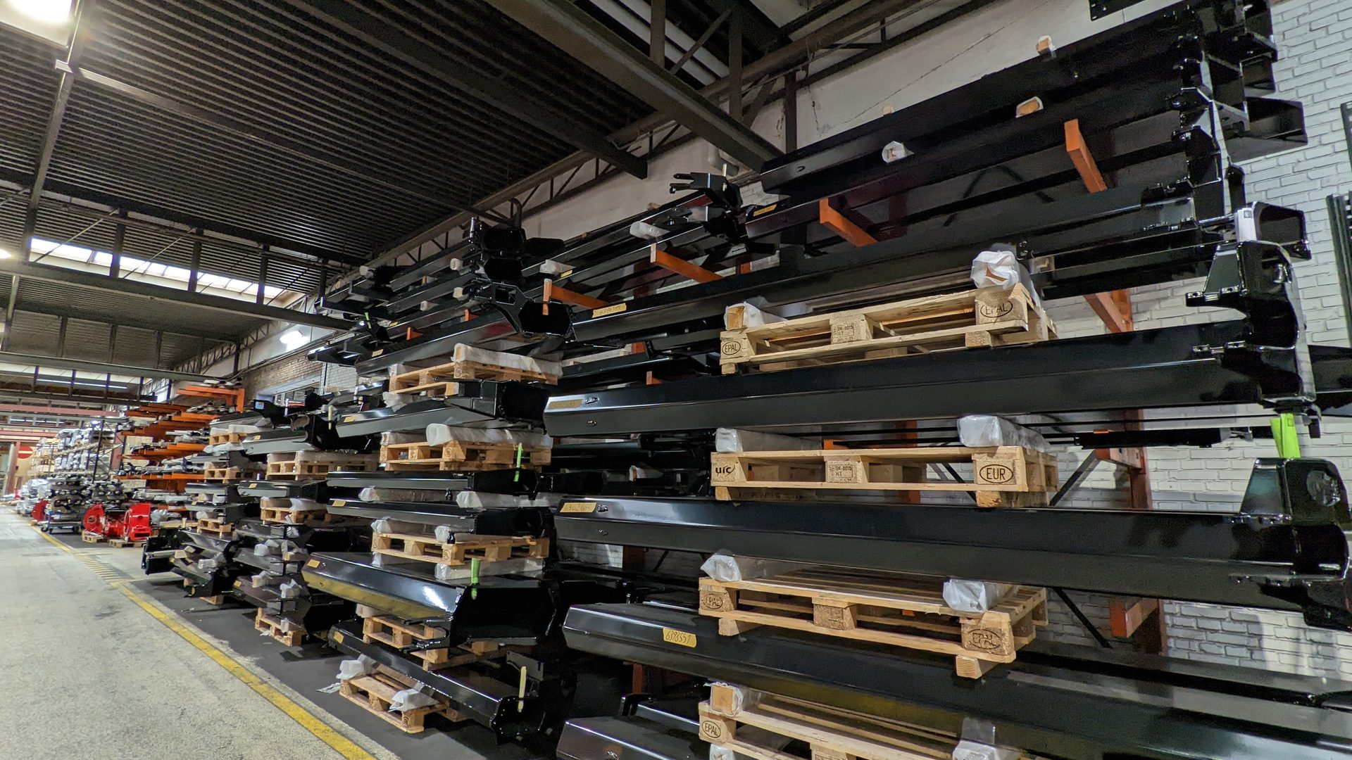 Rows and racks of configurable crane booms and components in a warehouse
